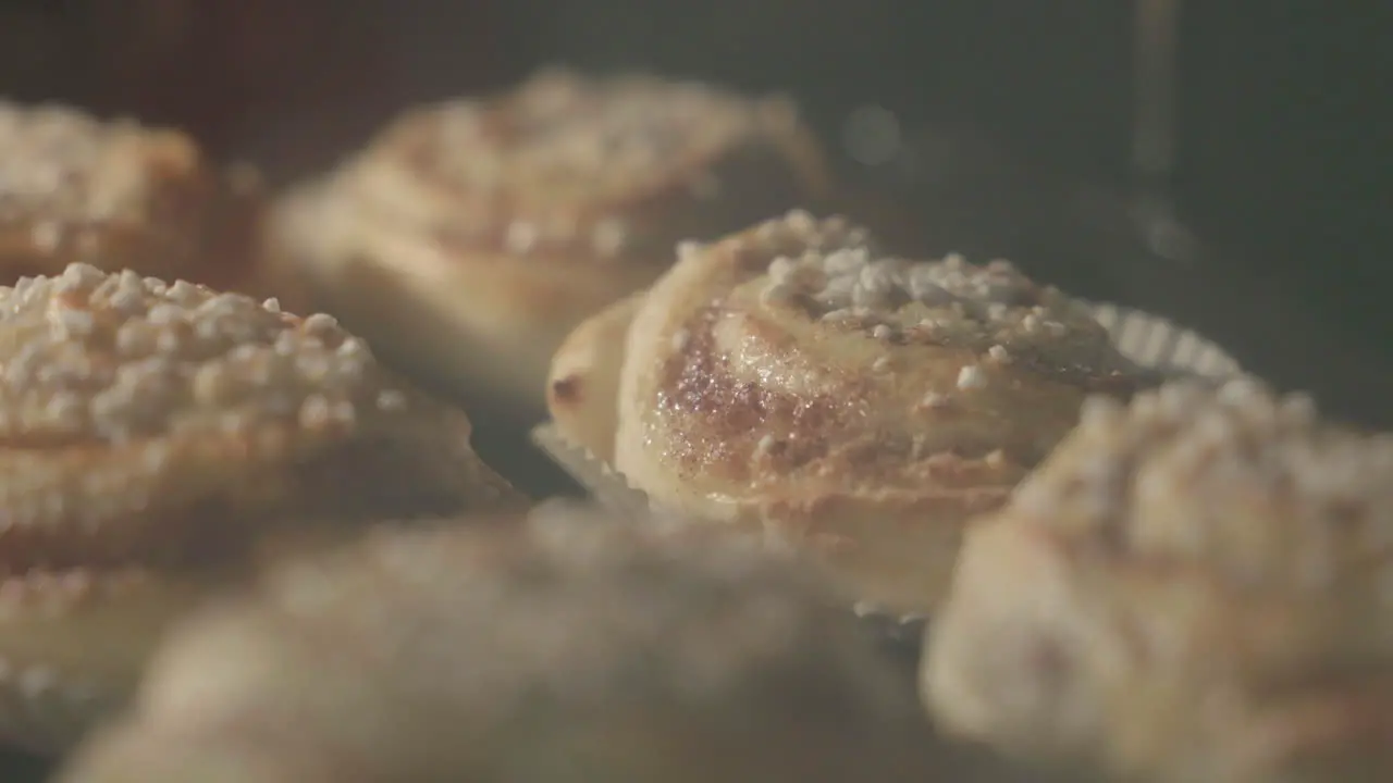 Close up of cinnamon buns getting baked in an oven