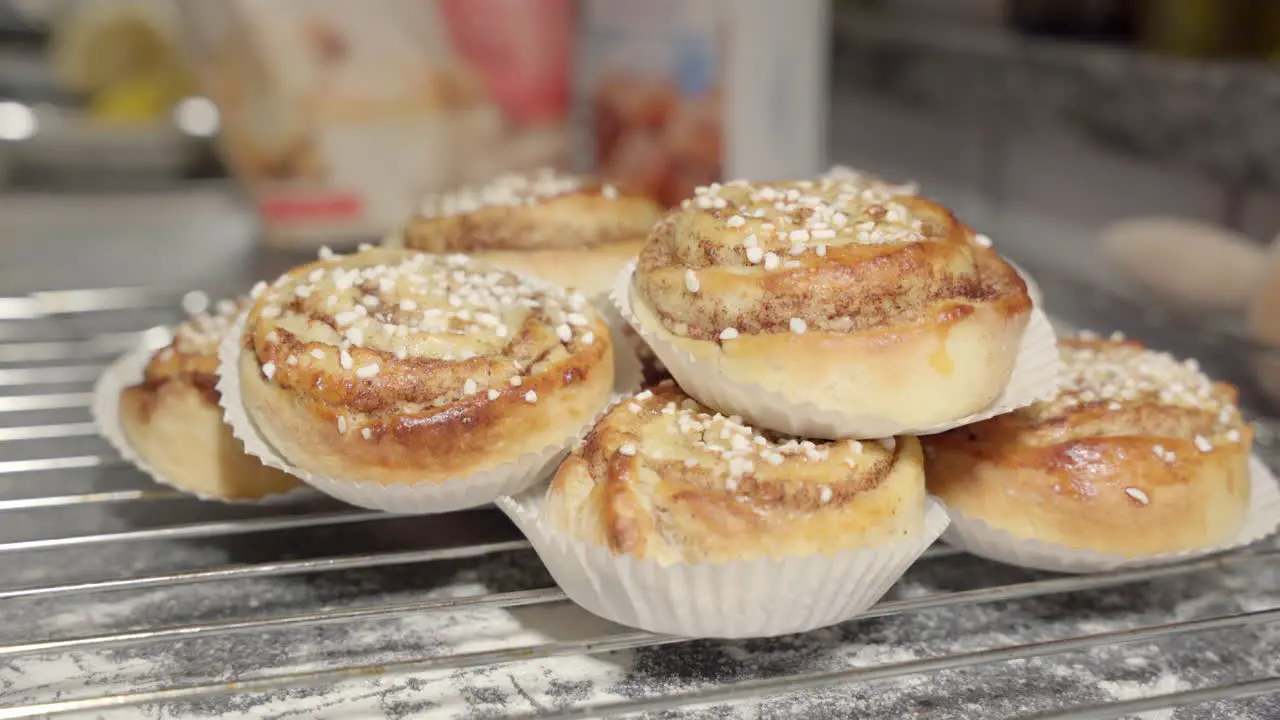 Male hand picking up a the cinnamon bun on top in the foreground