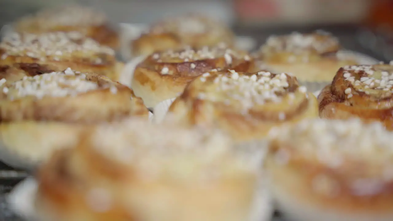 Medium static shot with focus being pulled over a pile of cinnamon buns