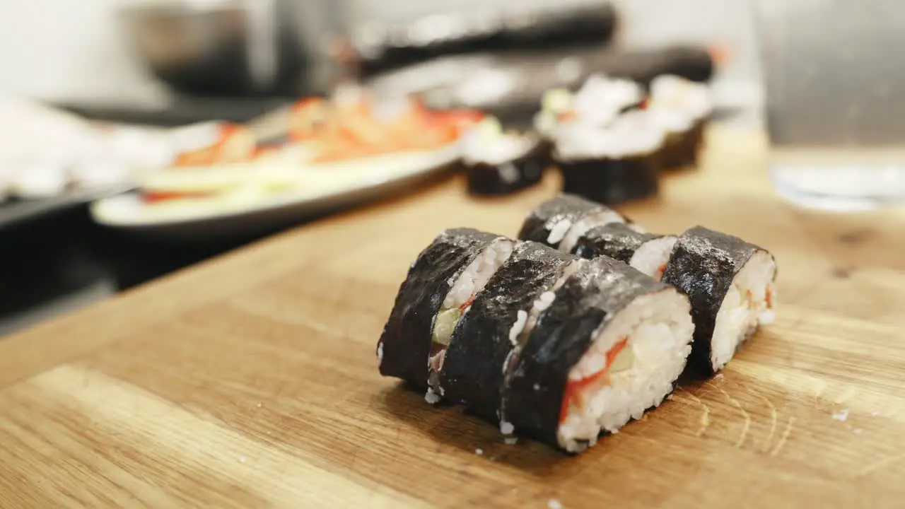 Person Holding With Knife Green Sushi Roll Slices Side By Side Homemade Preparation