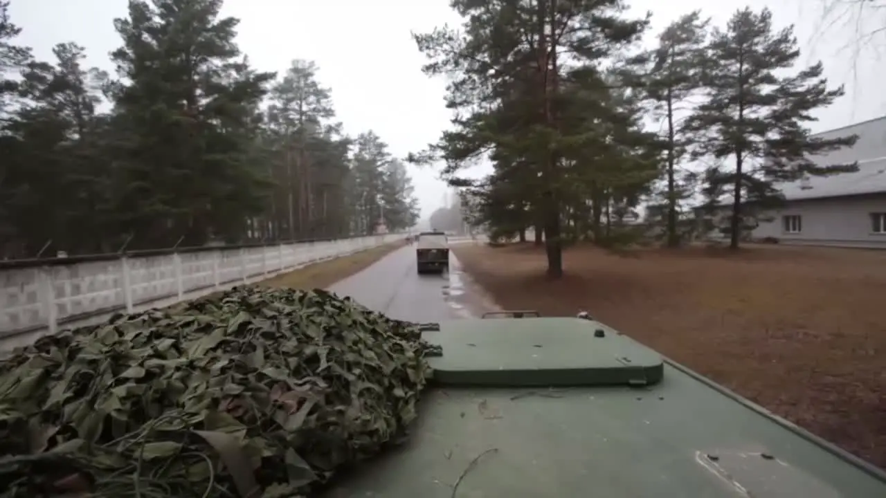 The Latvian Army Moves Across A Simulated Battlefield In Tracked Tanks And Vehicles