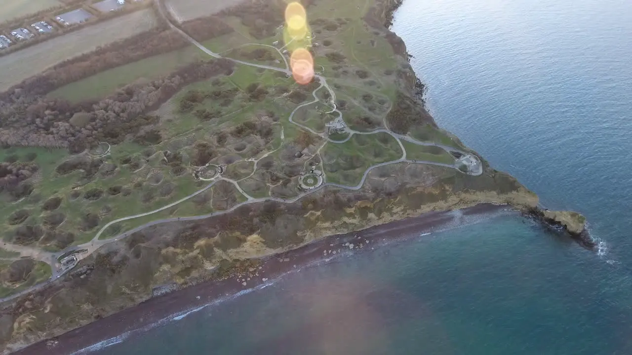 Drone sunset flare over la Pointe du Hoc casemates and shell holes after WW2