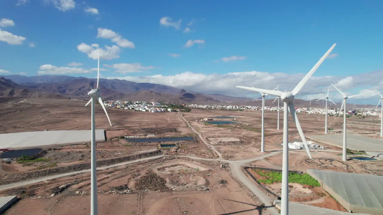 aerial view passing over a field of wind turbines in a desert landscape on the island of Gran Canaria on a sunny day