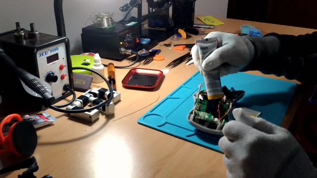 Gloved Hands Of Technician Applying Glue From Tube Onto Game Controller