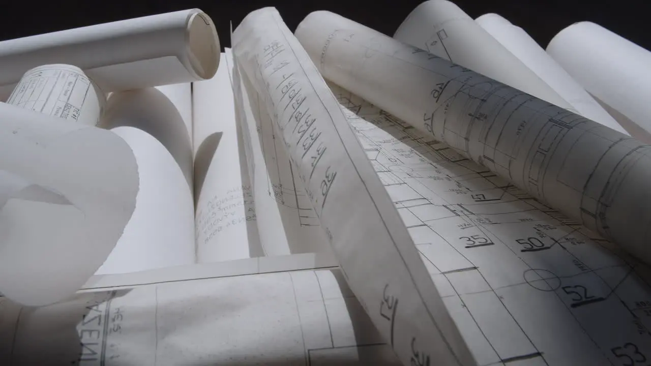 Paper rolls of construction plans lying on the floor in the shade