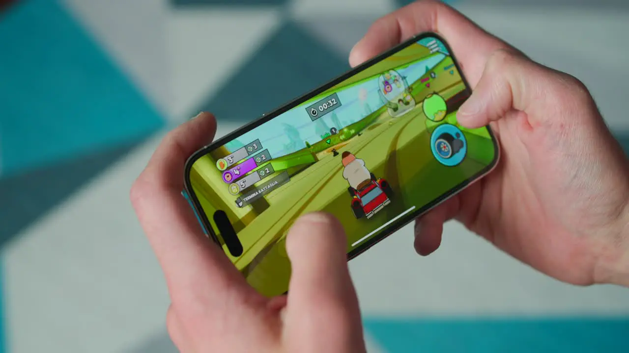 Person Holding Smartphone In Landscape Mode Playing Racing Game On iPhone 14