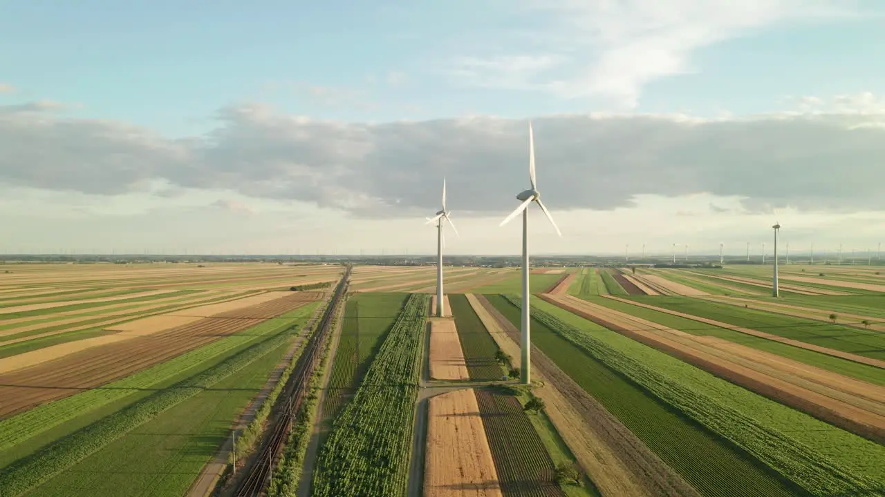 Aerial follow footage of wind turbines on a field 