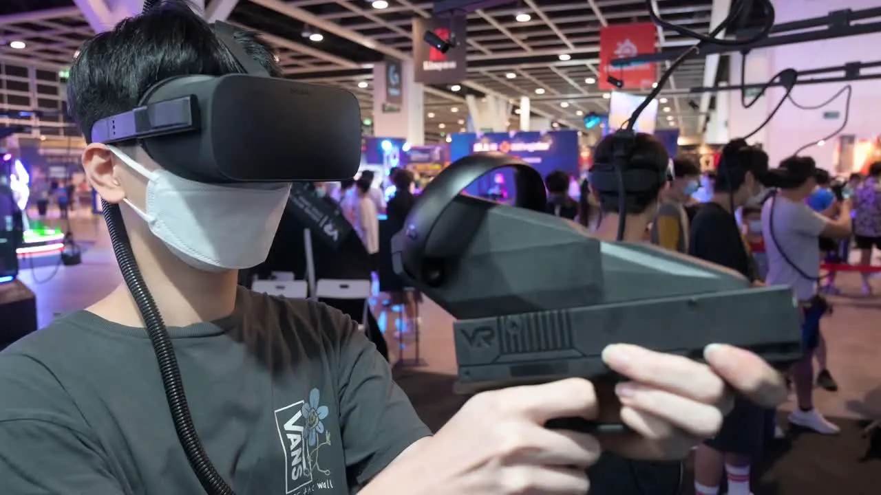 Chinese gamers and visitors play Virtual Reality multiplayer shooting videogames during the Hong Kong Computer and Communications Festival in Hong Kong