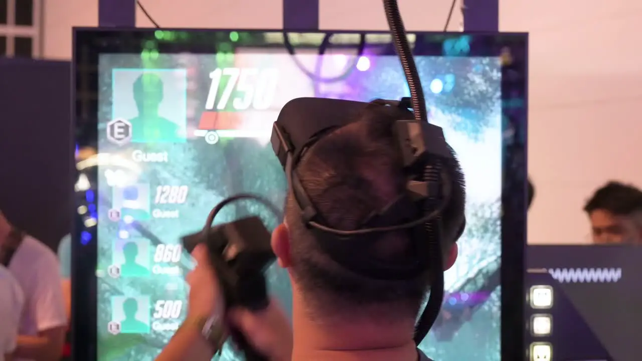 A Chinese gamer plays a Virtual Reality shooting videogame as he reloads points and shoots at a target during the Hong Kong Computer and Communications Festival in Hong Kong