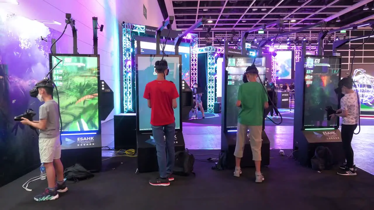 Youth Chinese gamers and visitors play Virtual Reality multiplayer shooting videogames during the Hong Kong Computer and Communications Festival in Hong Kong