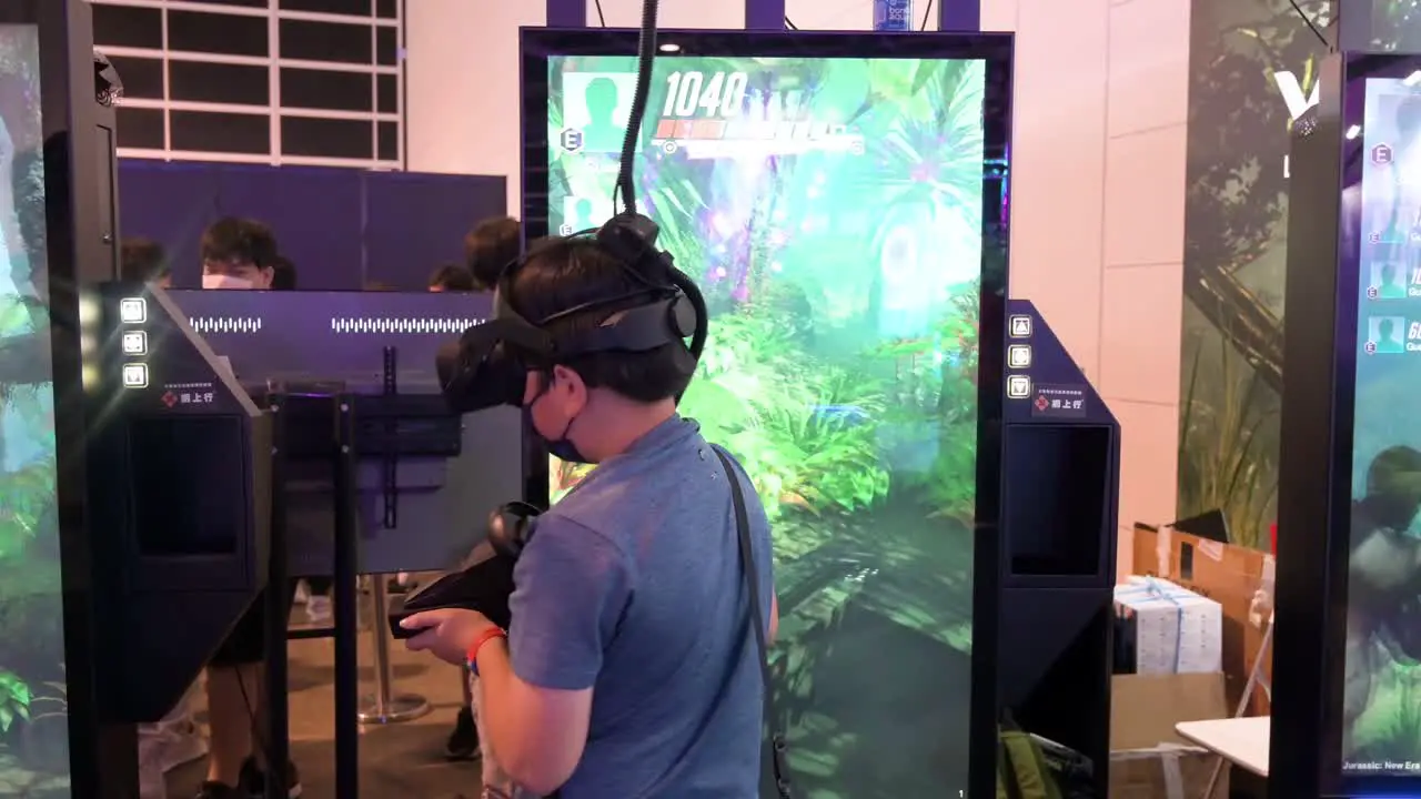 A young Chinese gamer plays a Virtual Reality shooting videogame as he turns around to find a target during the Hong Kong Computer and Communications Festival in Hong Kong