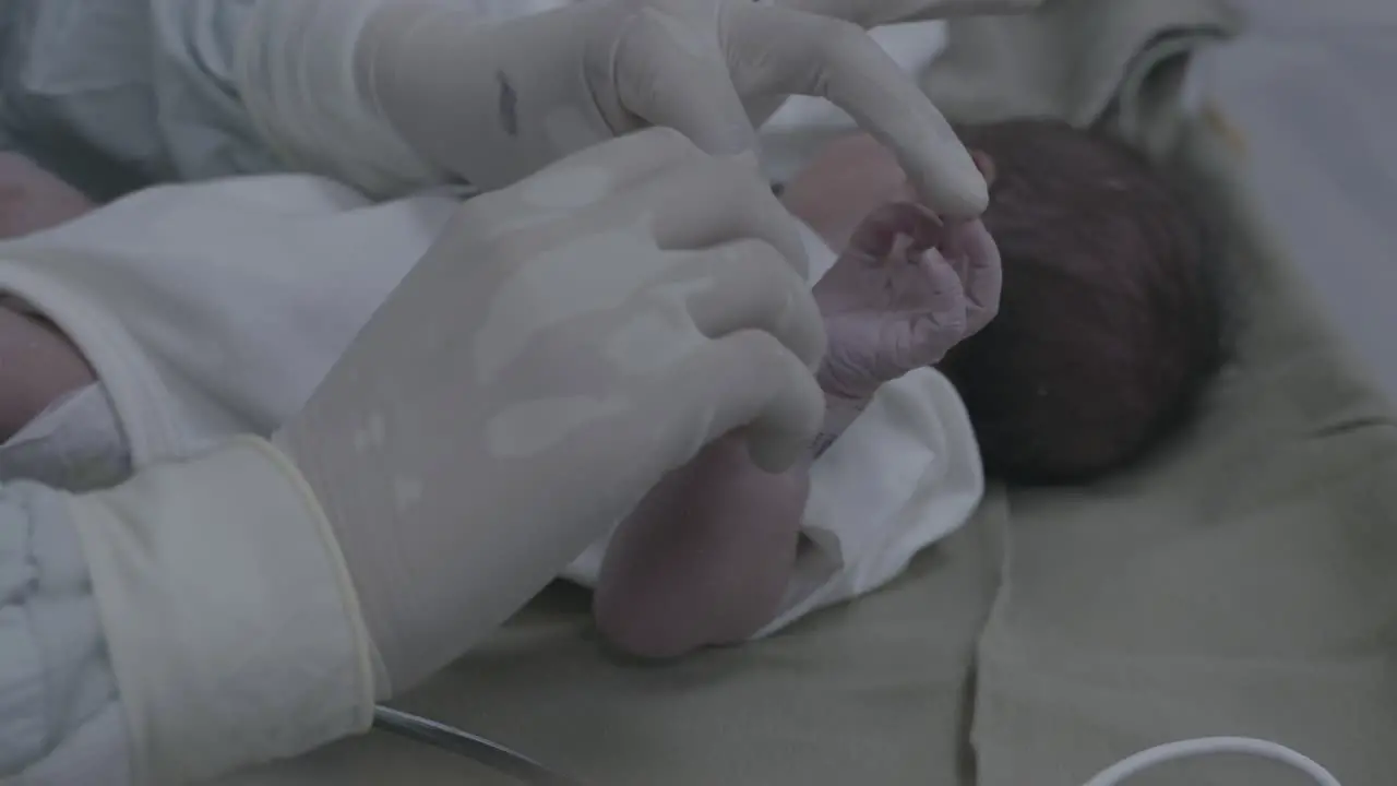 Close-up putting on neonatal identification code bracelet for a newborn baby