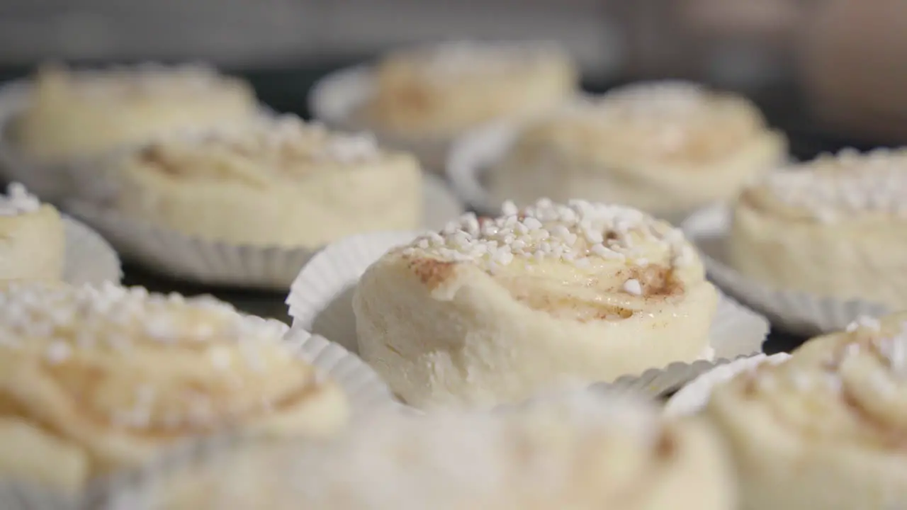 Static close up of cinnamon buns on a black tray