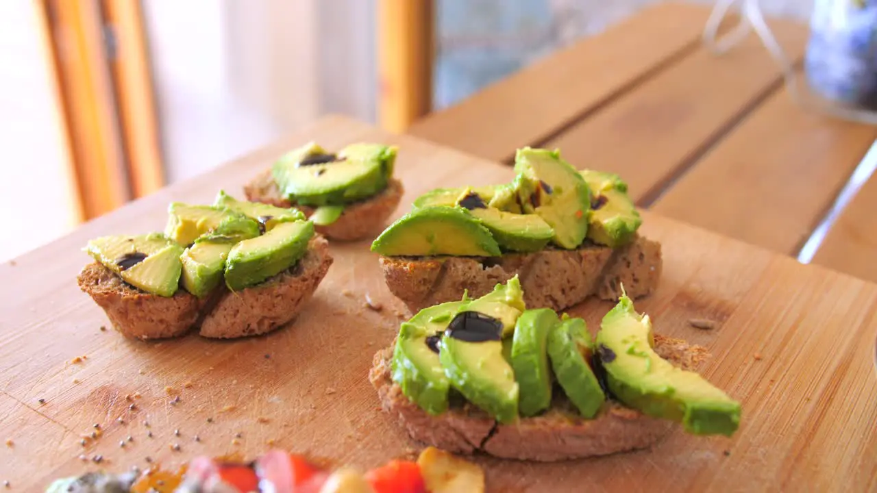 Close up view of nutritious breakfast toast of homemade bread along with pieces of green Avocado