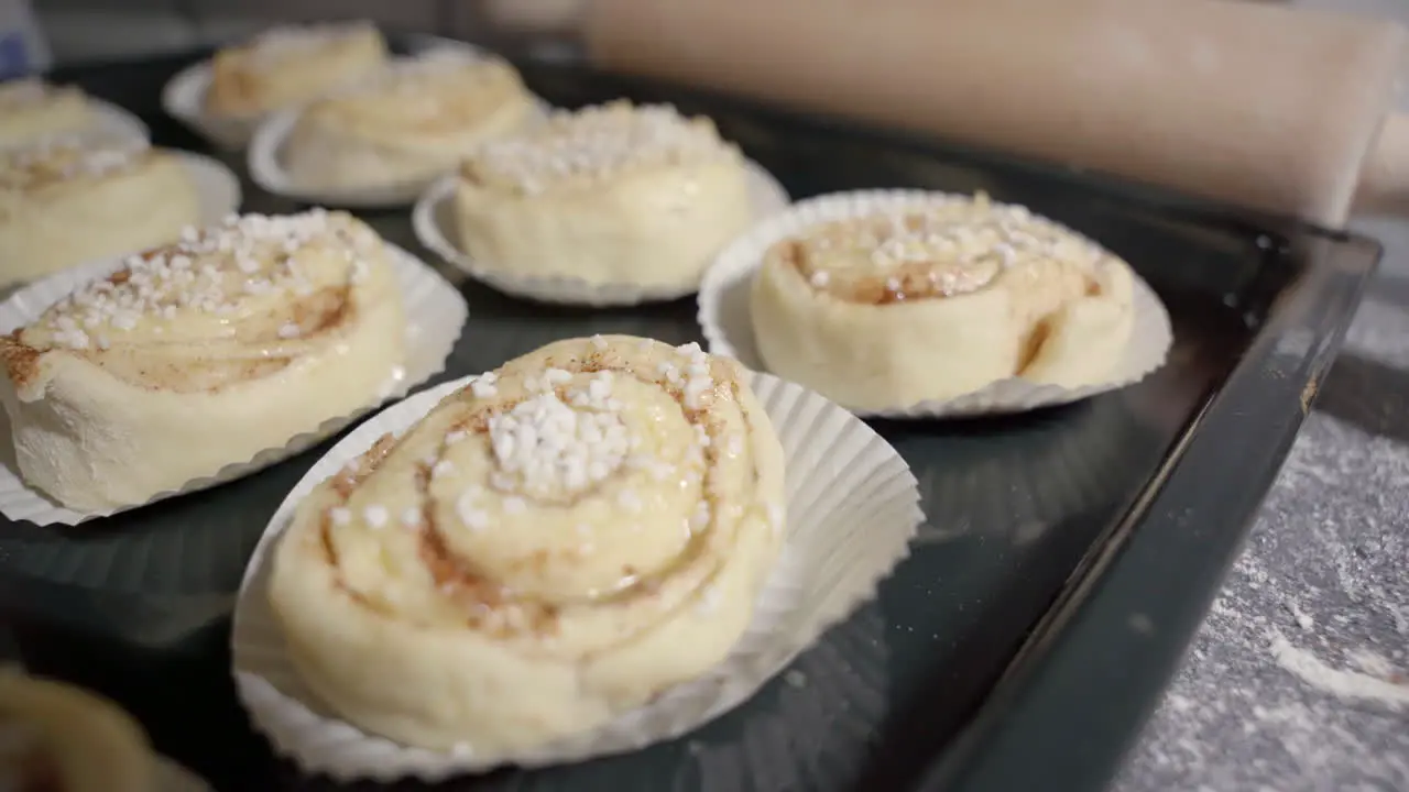 Static shot with focus shift of a tray with unbaked cinnamon buns