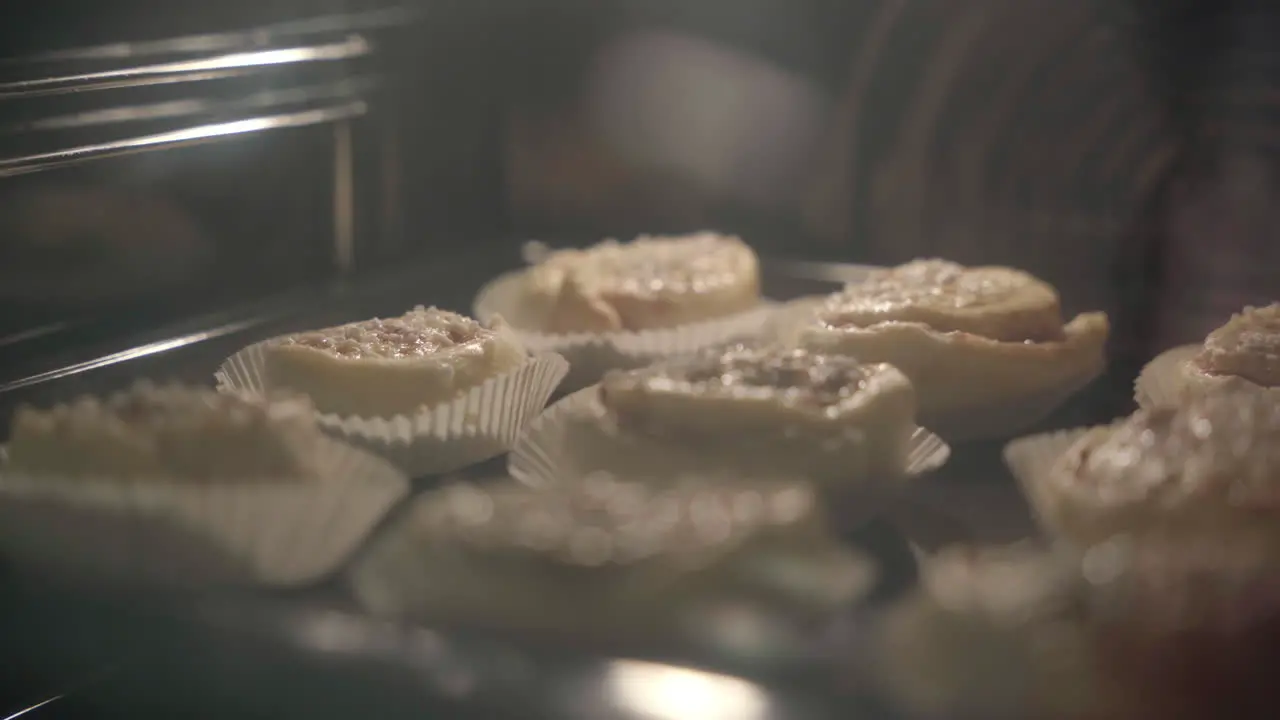 Medium handheld shot of cinnamon buns getting baked in the oven