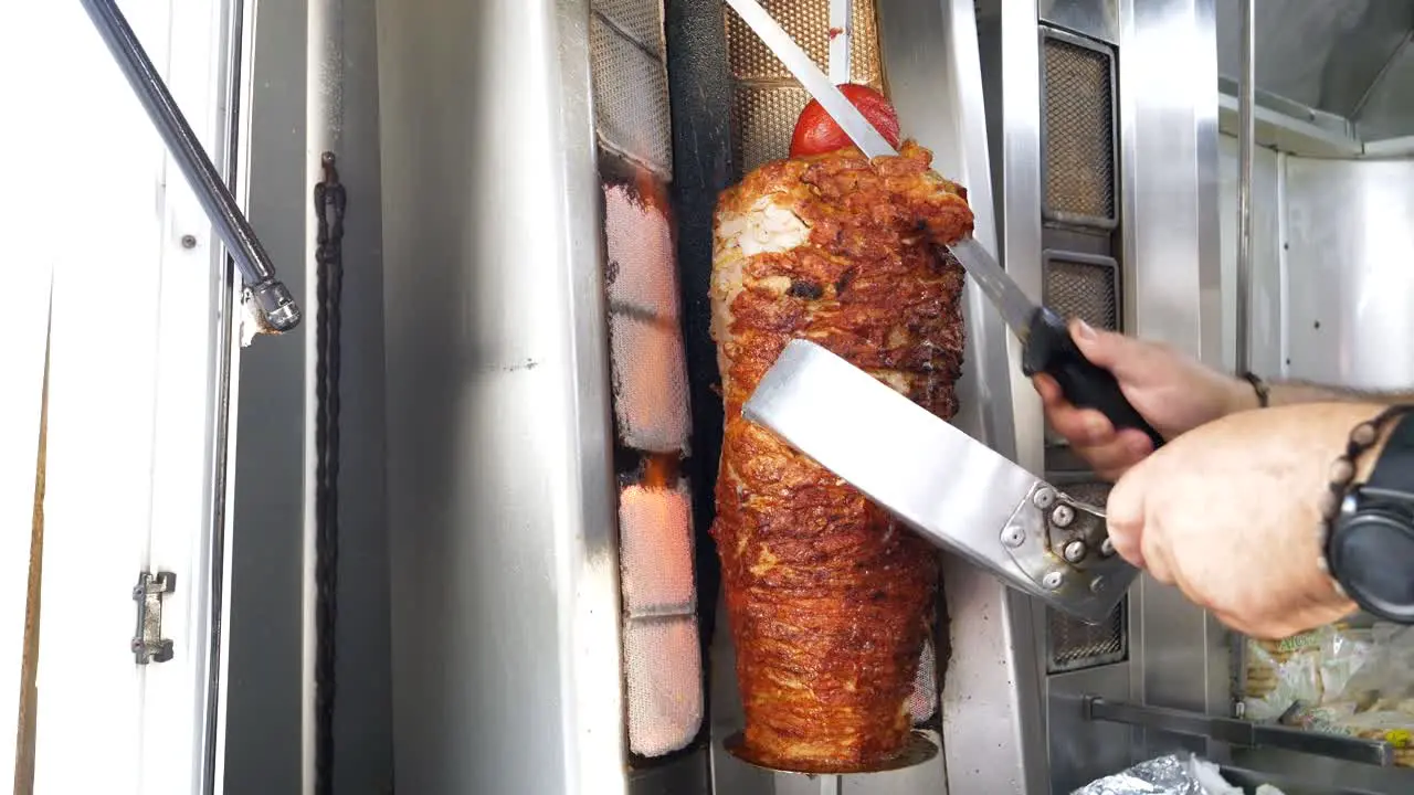 Fast food a man slicing grilled chicken and beef meat