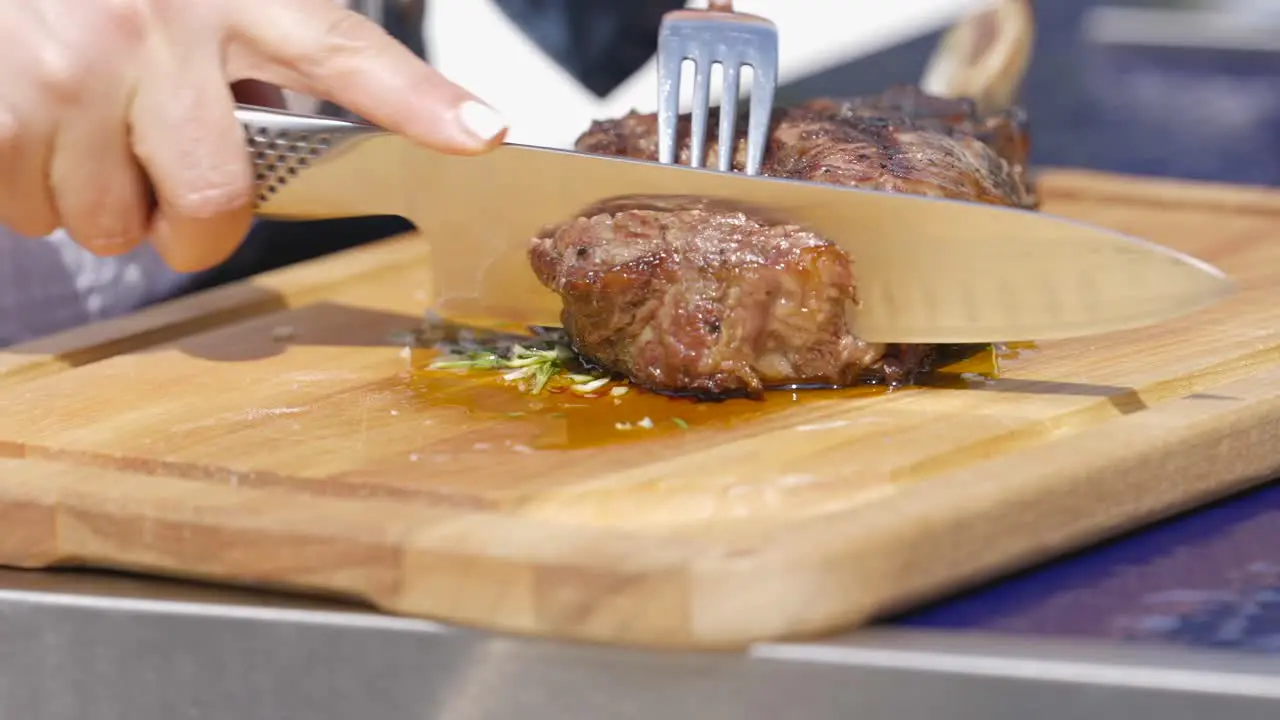 Sharp knife cutting into a tomahawk steak