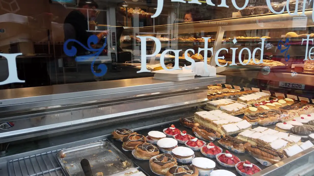 Looking at delicious cakes display in Conwy bakery cake shop window display