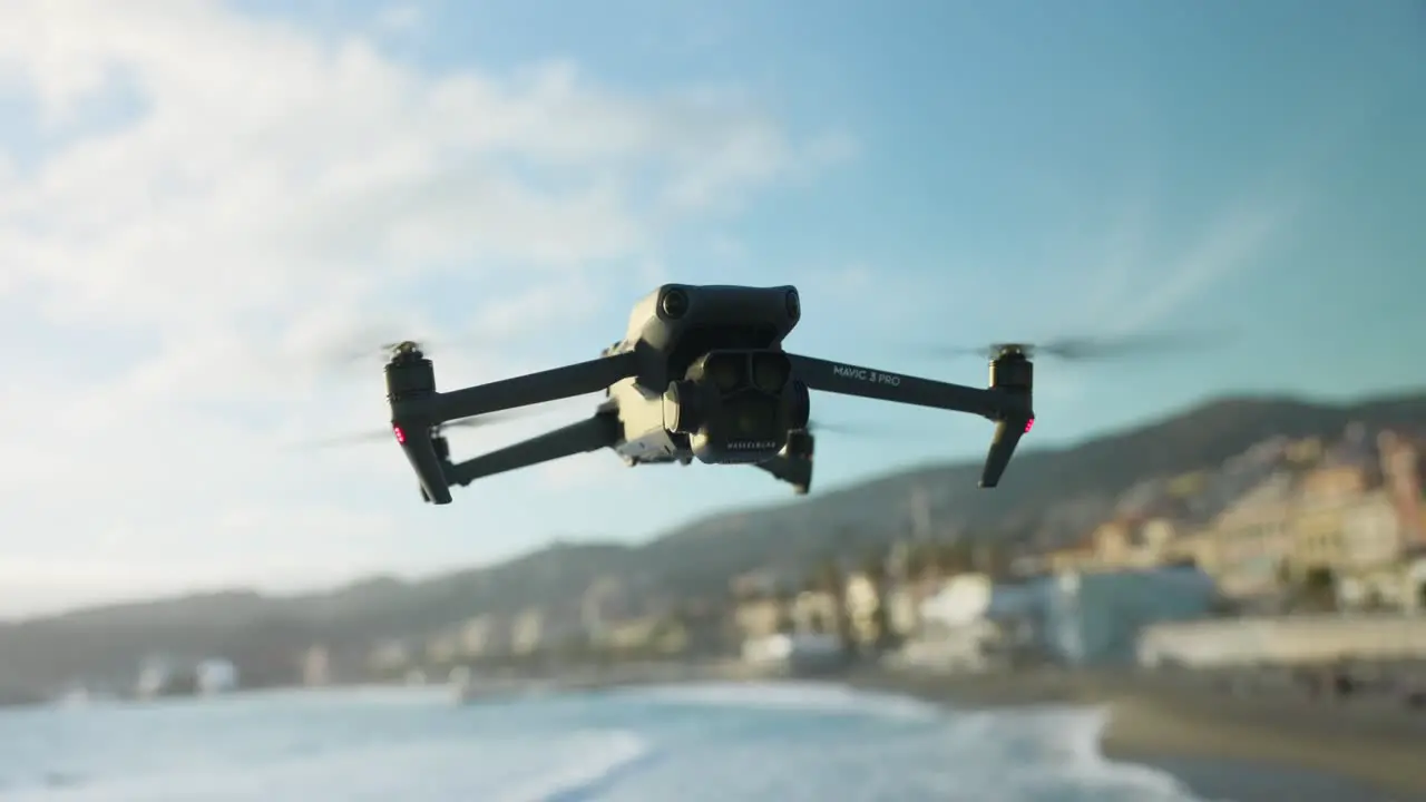 DJI Mavic 3 Pro Hovering In Mid Air With Bokeh Beach Coastline Background