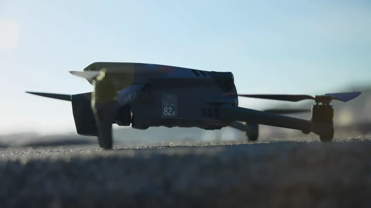 Close Up View Of DJI Mavic 3 Pro On Ground With Lens Flare In Shot