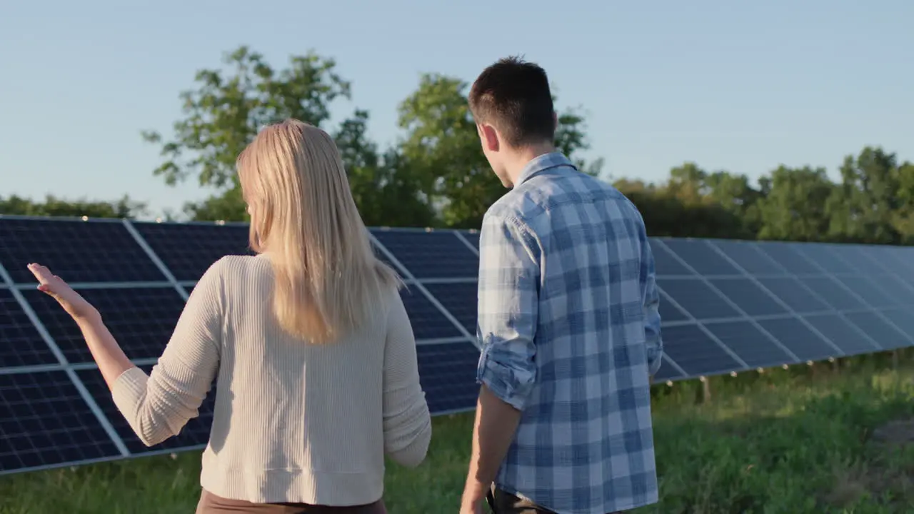 Two people are talking around solar panels at a small home solar power plant Ecologically clean production of electricity