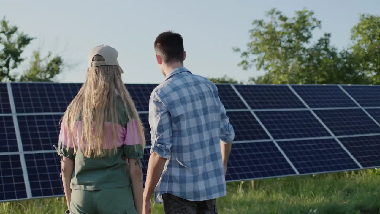 A young man tells a teenage girl about a solar power plant