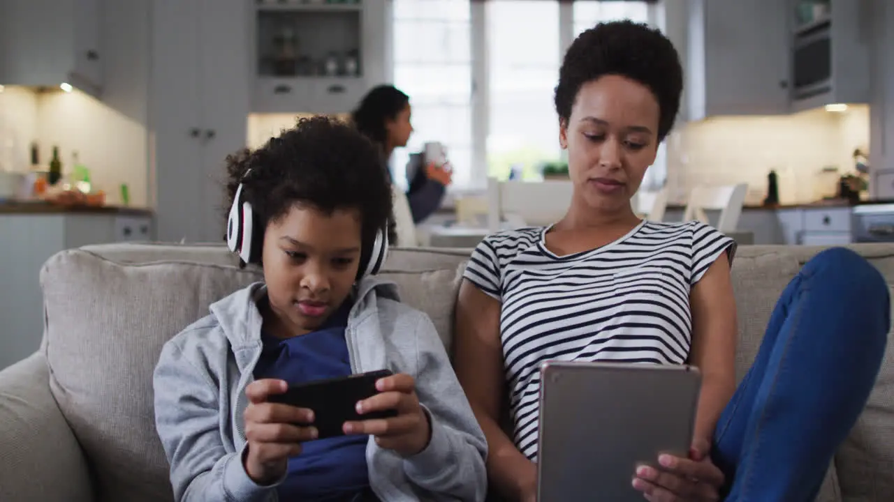 Mixed race mother and daughter using a tablet and smartphone