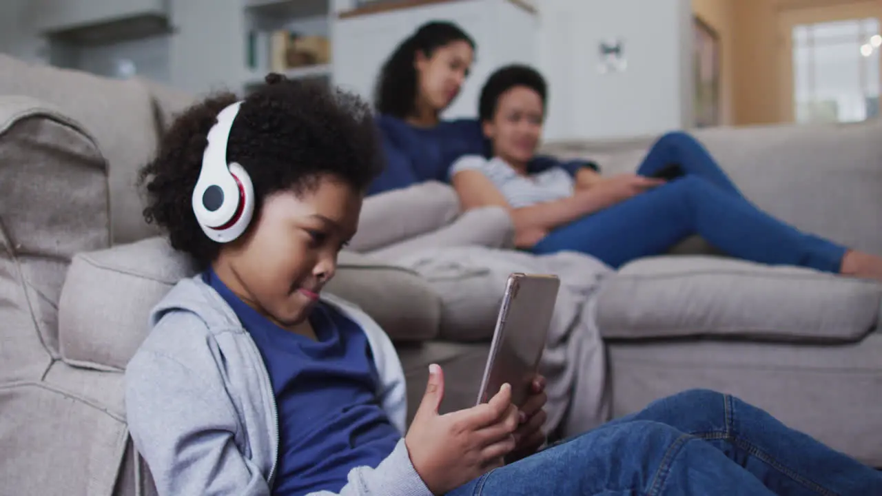 Mixed race girl using tablet wearing headphones