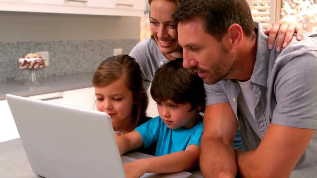 Family using laptop in kitchen