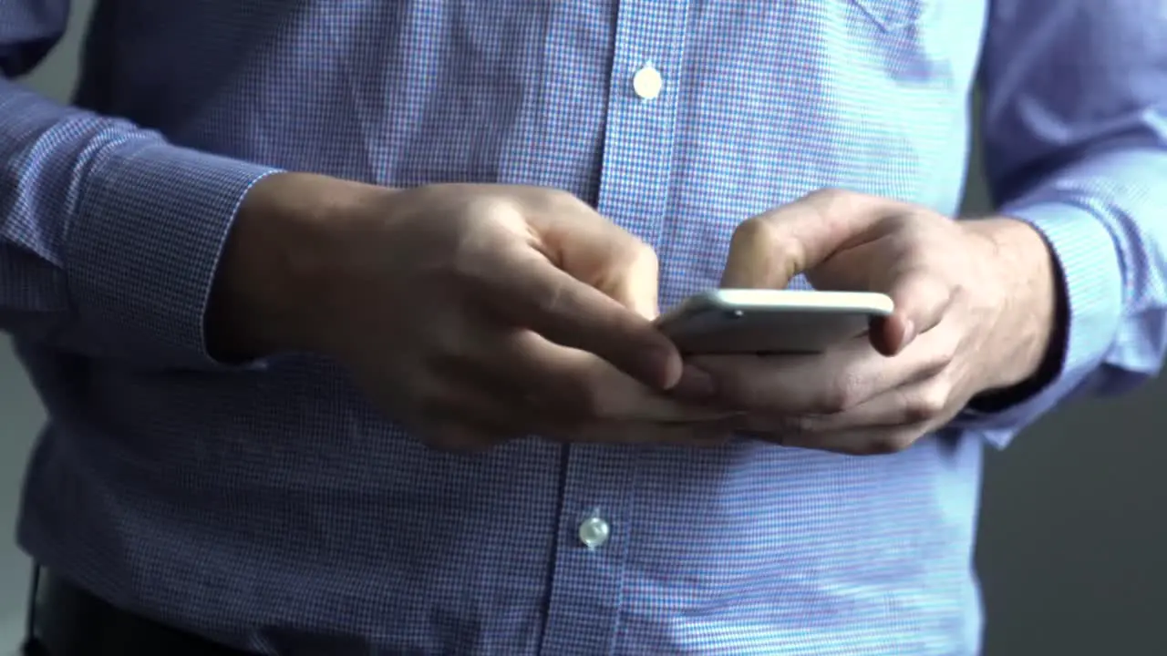 Man using smart phone holding and typing on cell phone in hands