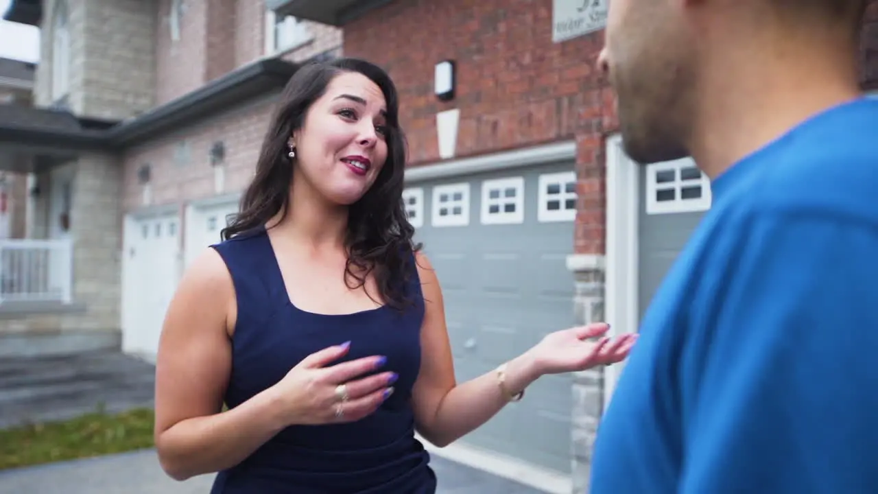 Enthusiastic real estate agent talking to a client outside of a home