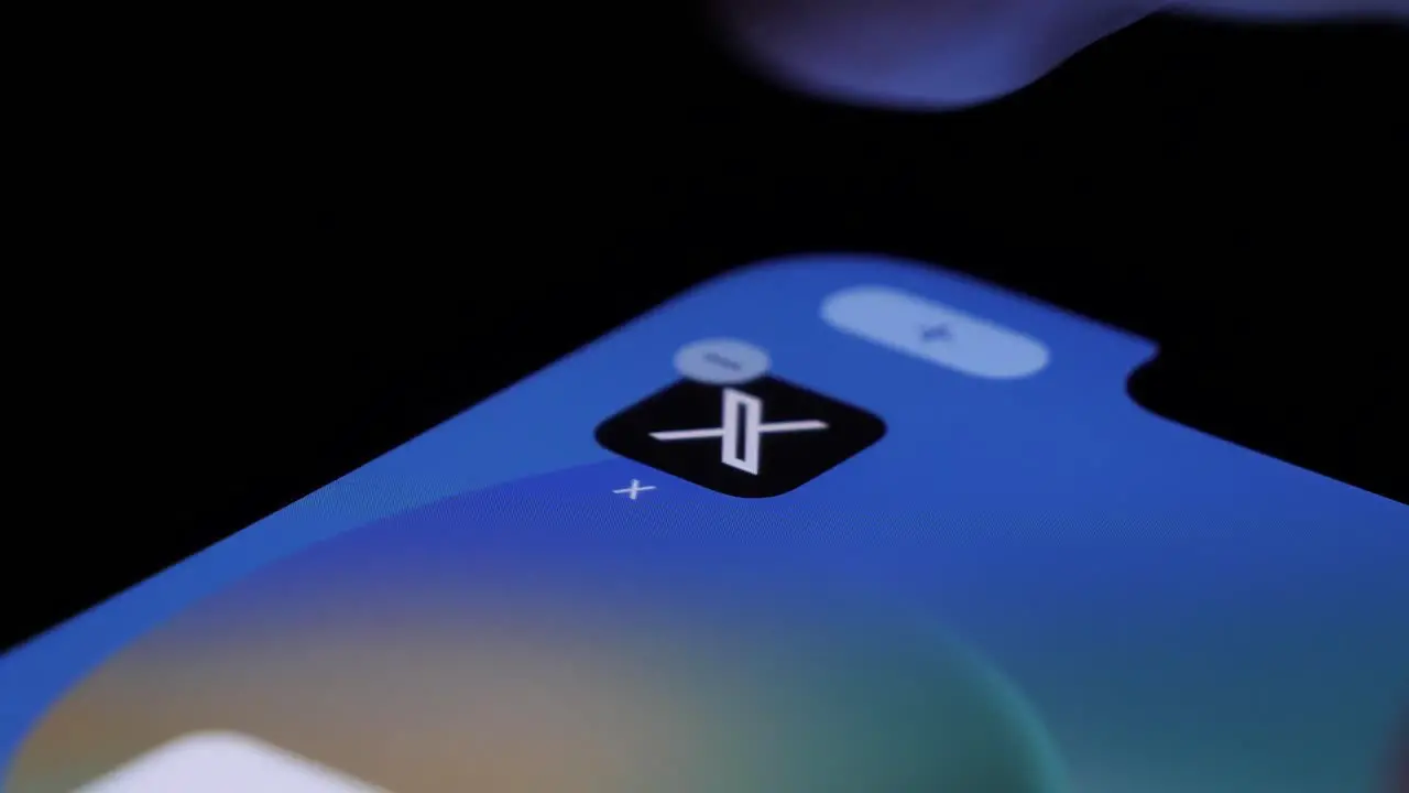 New X Twitter app logo on smartphone screen getting deleted close up view