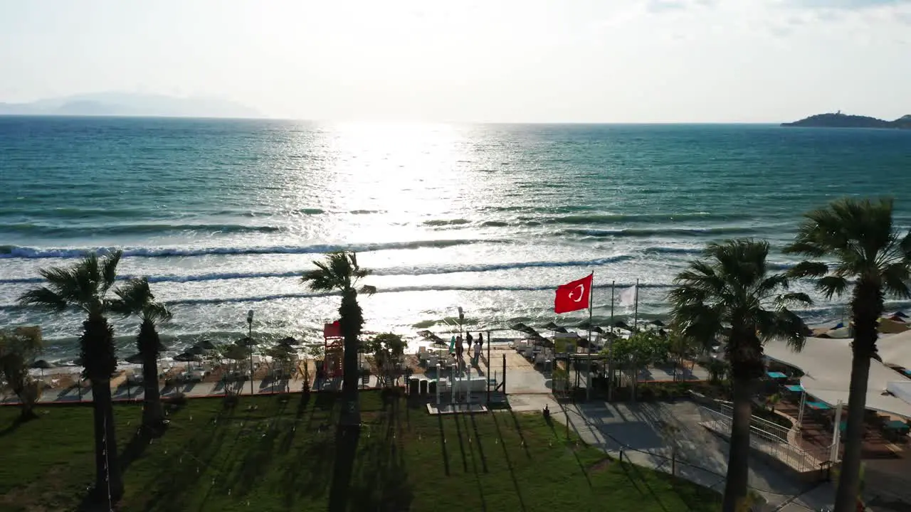 Turkish flag is waving in wind on sandy beach famous tourist destination in Kusadasi