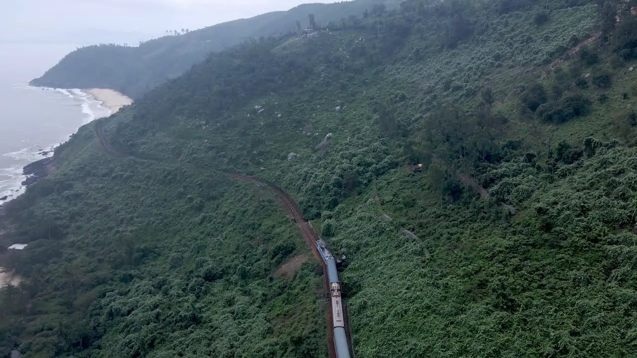 Drone flying over train alongside coast of Vietnam