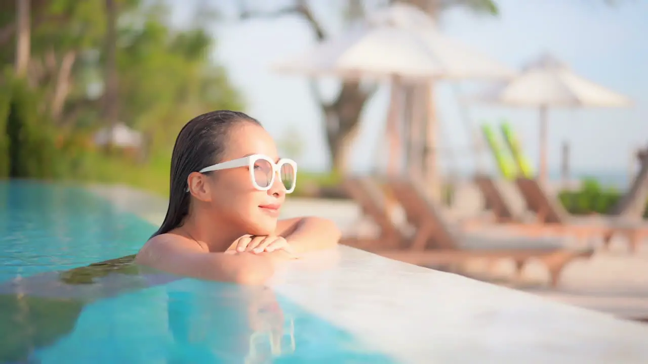 A pretty young woman fresh from swimming rests her chin on her hands