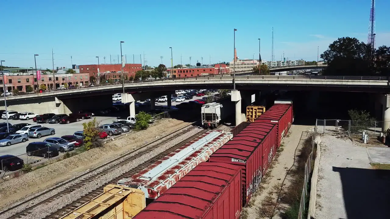 Aerial shot of cargo train going under a bridge