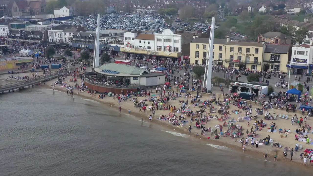 Very busy beach Southend shakedown seafront beach bar and amusements in background