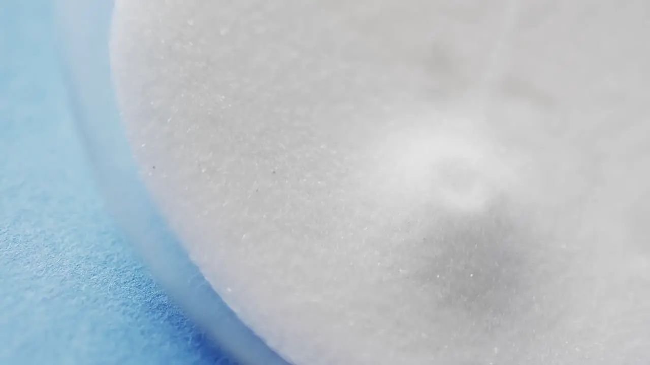 Video of close up of hourglass with white sand pouring with copy space on blue background