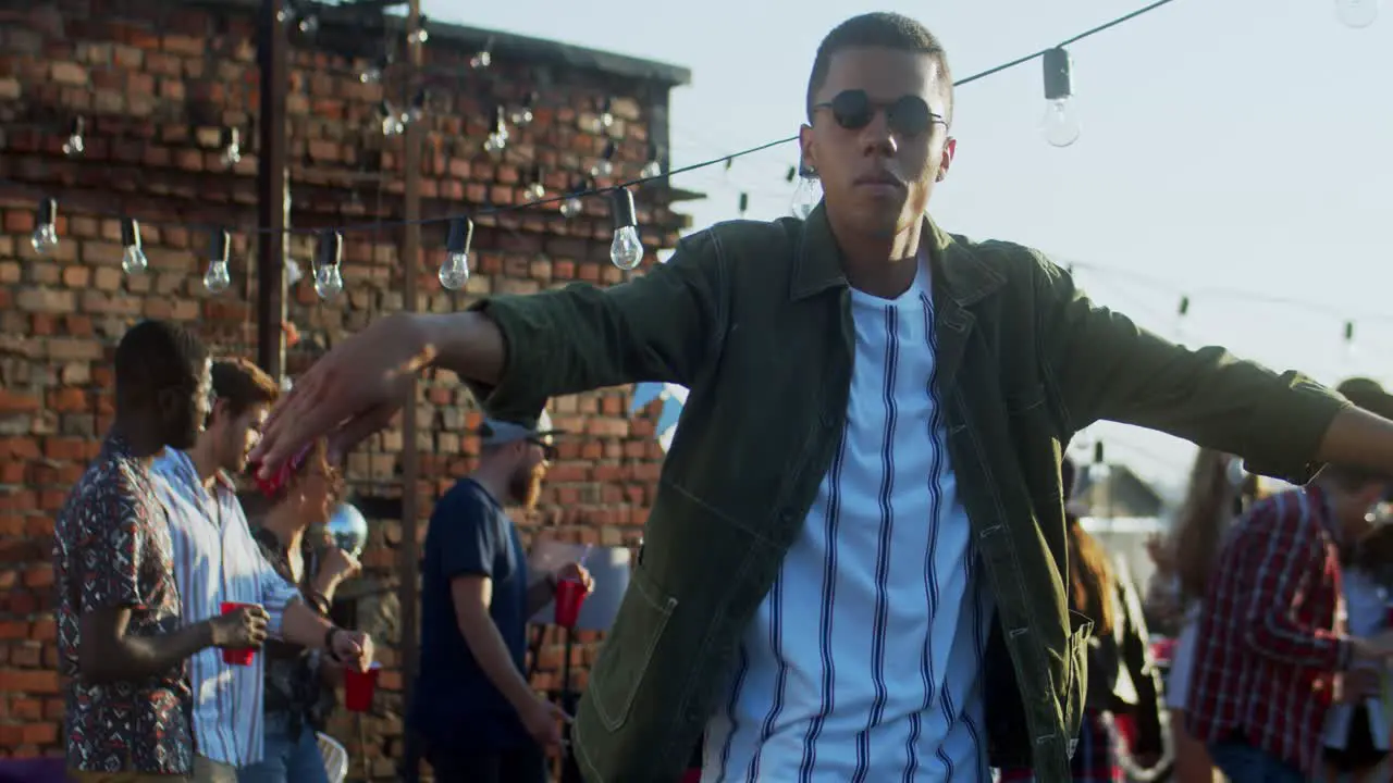 Young Stylish Guy In Black Sunglasses Dancing Cheerfully In Front Of The Camera At The Rooftop Party At Daytime 2