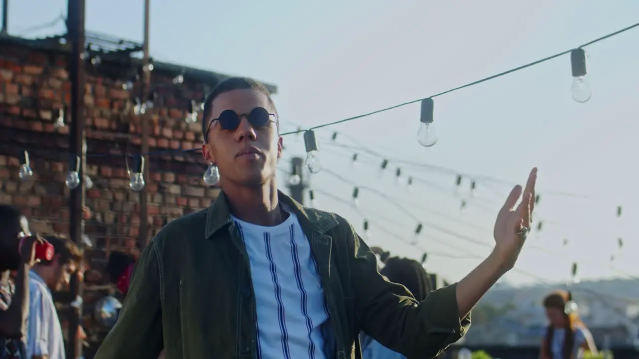 Young Stylish Guy In Black Sunglasses Dancing Cheerfully In Front Of The Camera At The Rooftop Party At Daytime