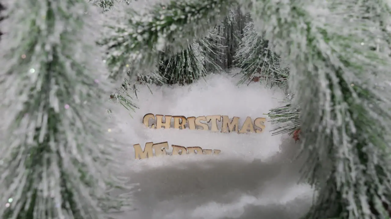 snowing over Merry Christmas greeting surrounded by trees