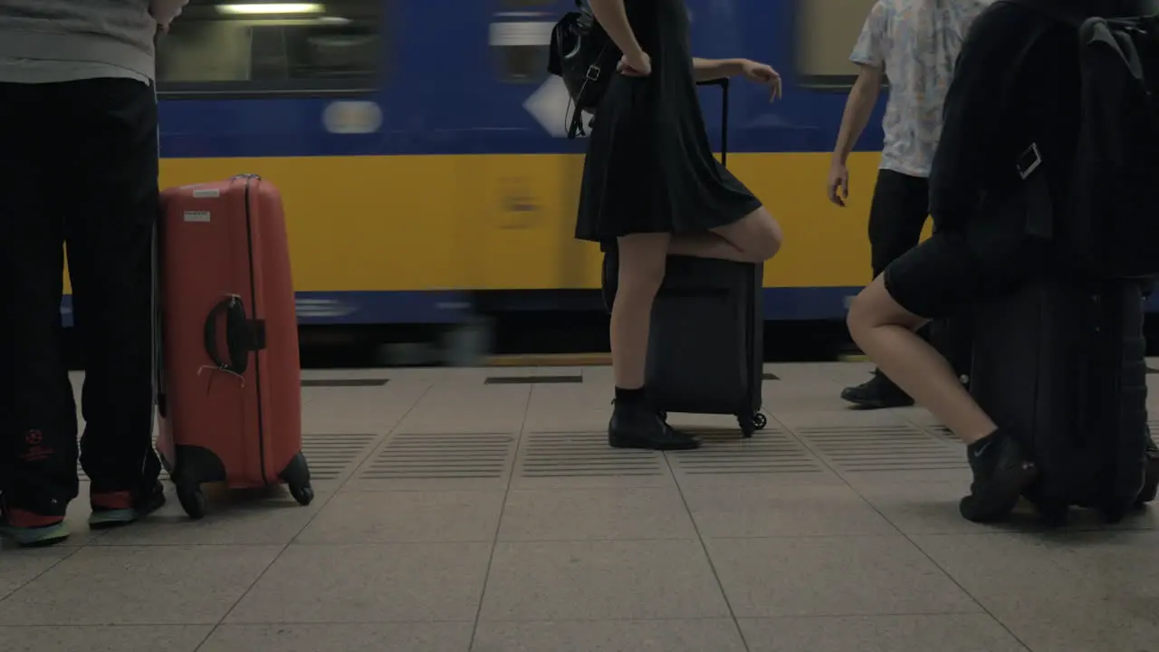 People with baggage waiting for the train at railway station