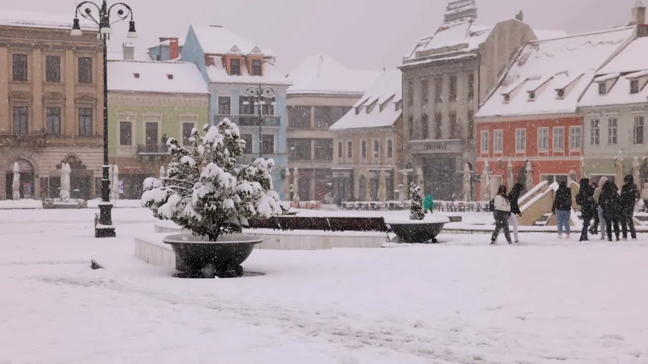 People On The Main Square Of The Old City Of Brasov In Transylvania Romania During A Snowy Daytime