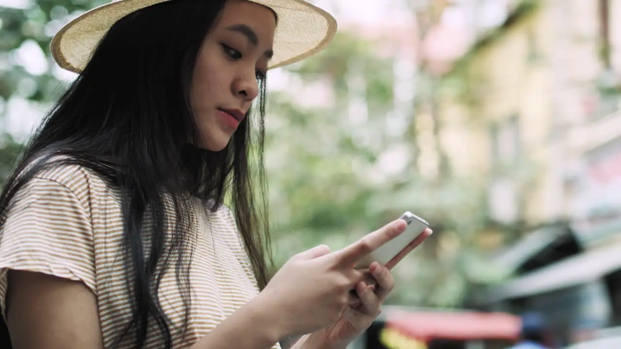 Handheld view of focused woman using mobile phone