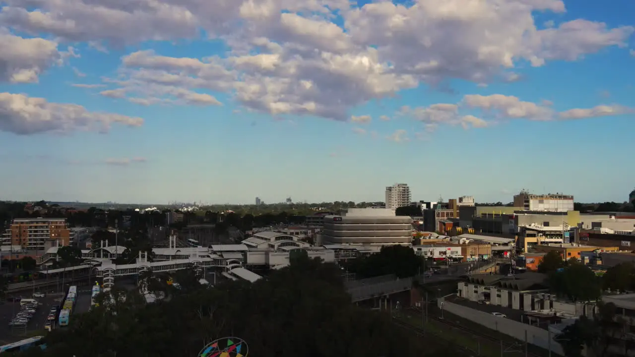 Descending Aerial shot of Australian roads in busy suburb with Railway traffic and cars and businesses Blacktown NSW