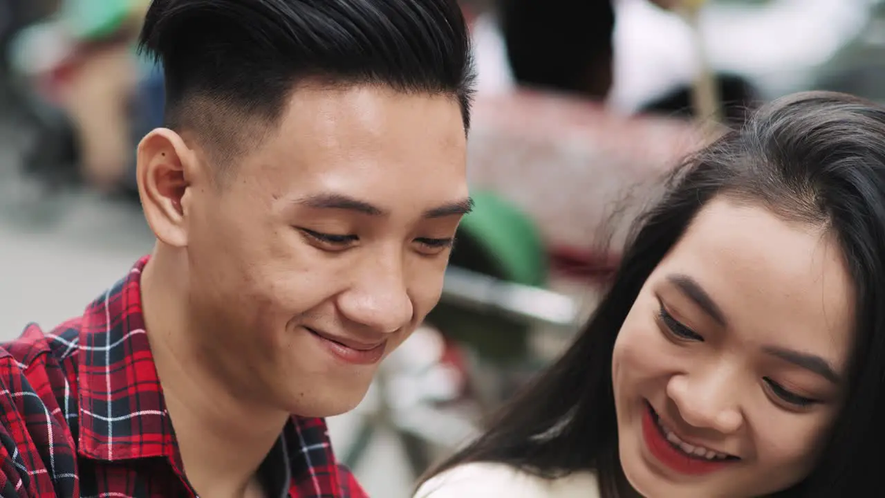 Handheld view of young Vietnamese couple making a selfie