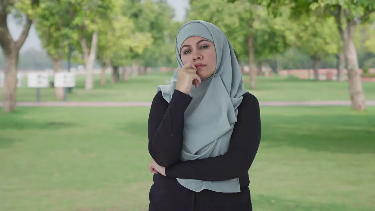 Confused Muslim woman thinking something in park