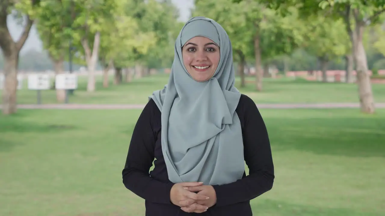 Happy Muslim woman smiling on camera in park