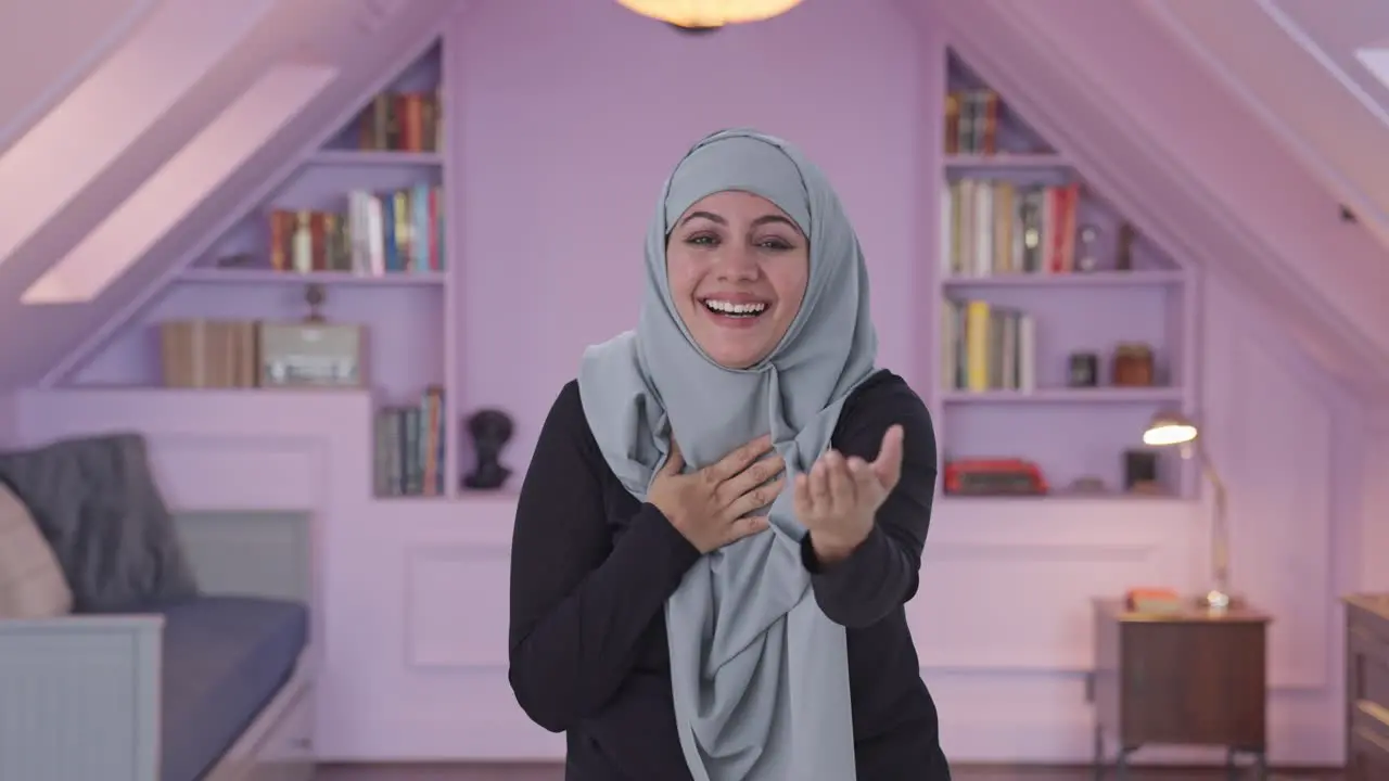 Happy Muslim woman laughing on someone